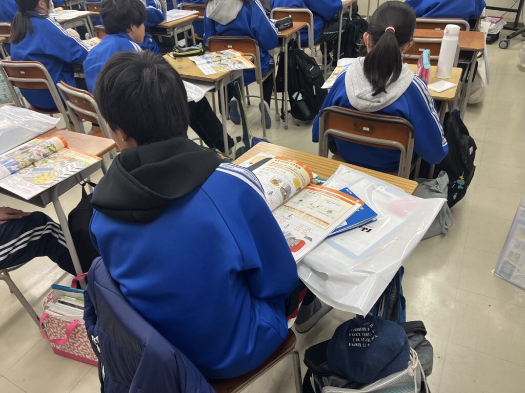 はまっ子防災ガイドを開いて授業を受ける中学生たち