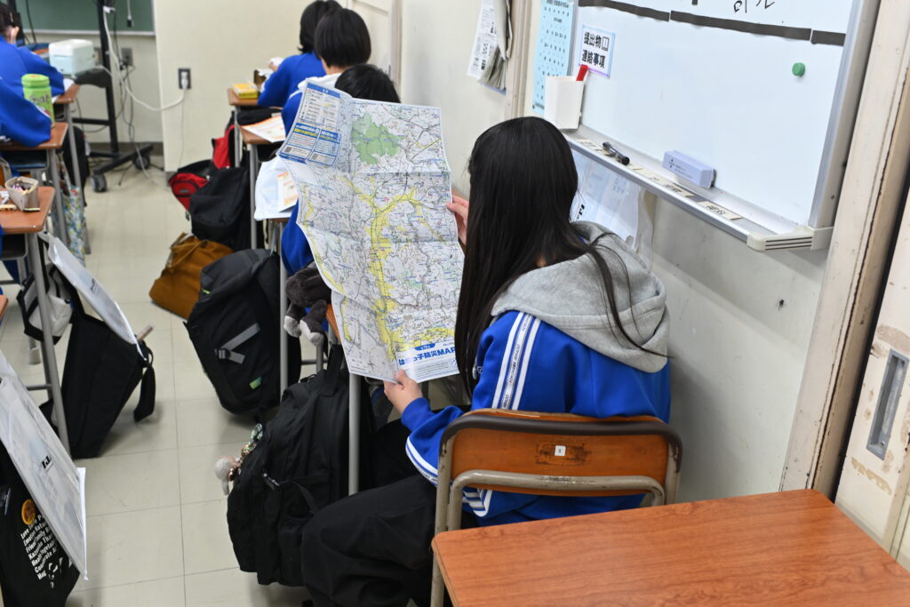 はまっ子防災MAPを使って避難の流れを確認する中学生